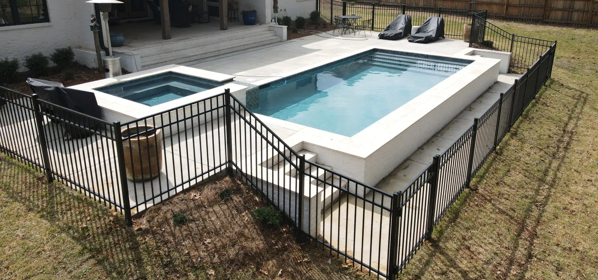 black aluminum fence installed around a swimmin pool area